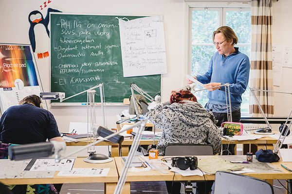 Opettaja Jussi Seppänen opettaa sarjakuvalinjan opiskelijoita luokan edessä