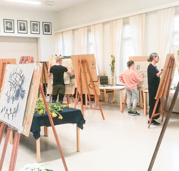 Opiskelijat maalaavat Muurlan opiston Isontalon salissa.