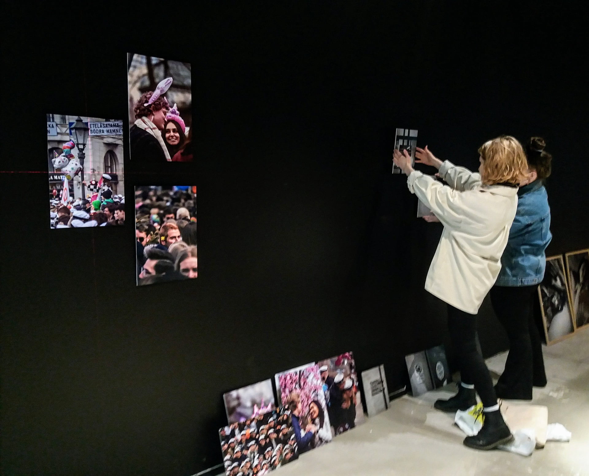 Muurlan opiston valokuvauslinjan opiskelijat ripustavat näyttelytilassa valokuviaan seinälle.