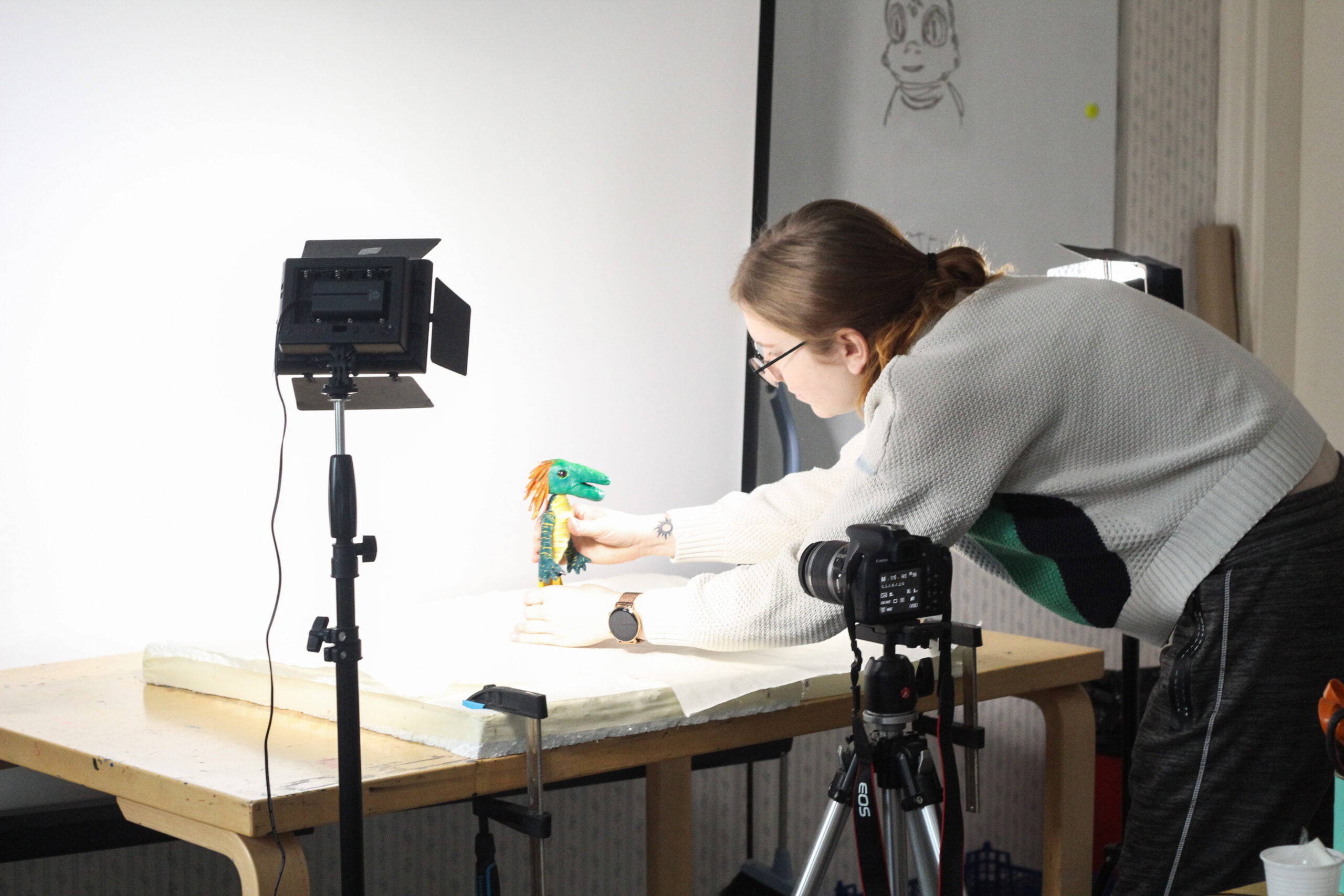Animaatiolinjan opiskelija kuvaa valmistamaansa nukkea animaation koulutustilassa