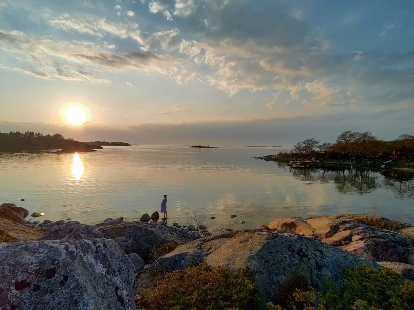 Työnohjauskolutuksen opiskelijan kuva. Maisemassa kaunis suomalainen järvimaisema, jossa henkilö rannalla.